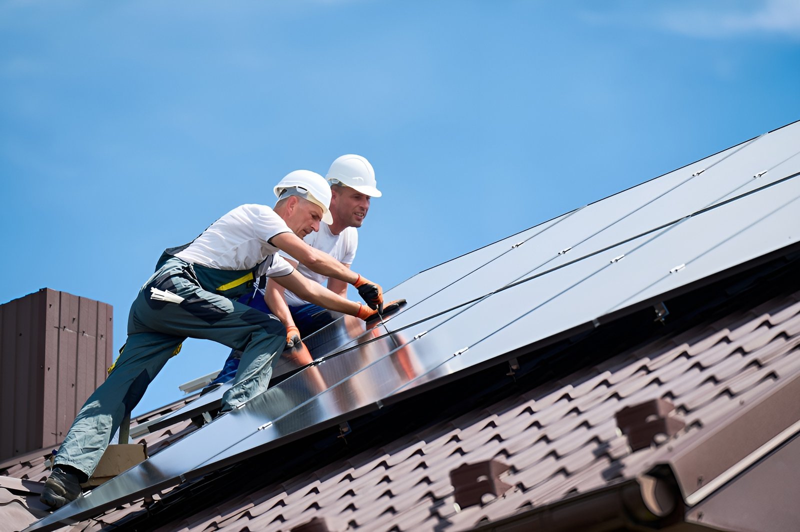 Roofing contractors installing metal roofing panels
