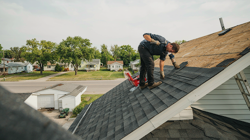 Professional roofer repairing damaged shingles in Regina Saskatchewan